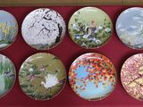 nine plates with different designs on them on a red surface