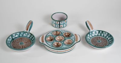 five pieces of pottery sitting on a white surface