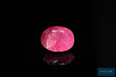 un gros plan d'une pierre rose sur une surface noire
