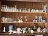 a wooden cabinet with many glasses and dishes on it