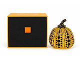 an orange and black ceramic pumpkin sitting next to a black box