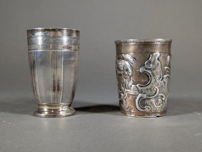 two silver cups sitting next to each other on a table