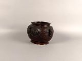 a small brown vase with a handle on a white surface