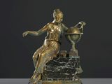 statue en bronze représentant une femme assise sur un rocher, tenant un globe terrestre