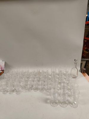 de nombreux verres à vin vides posés sur une table devant un fond blanc