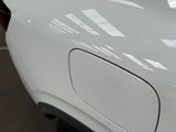 a close up of a white car with a red tail light