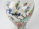 a white vase with a floral design on it