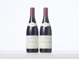 two bottles of wine sitting on top of a table next to each other