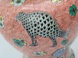 a pink vase with a black and white animal on it