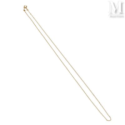 un gros plan d'un collier en or à longue chaîne sur fond blanc
