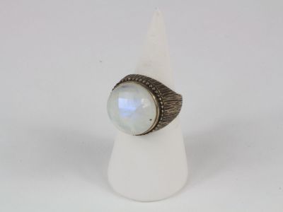 un gros plan d'une bague sertie d'une pierre blanche