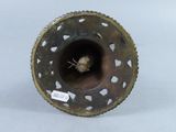 a metal object with holes in it on a white surface