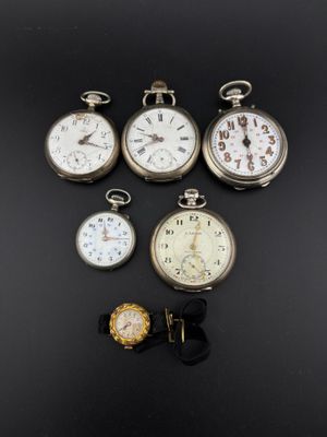 several different types of pocket watches are displayed on a black surface