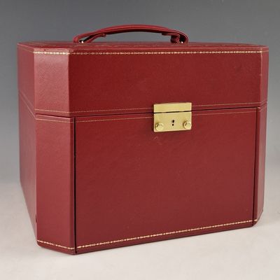 une image représentant une valise rouge munie d'un cadenas doré