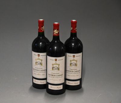 trois bouteilles de vin rouge posées sur une table