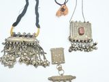 trois bijoux en argent posés sur une surface blanche