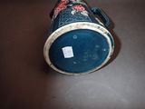 a blue cup with red flowers on it on a table