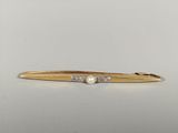 an image of a gold tie bar with a pearl on it