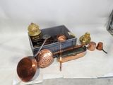 une boîte d'ustensiles de cuisine en cuivre posée sur une table