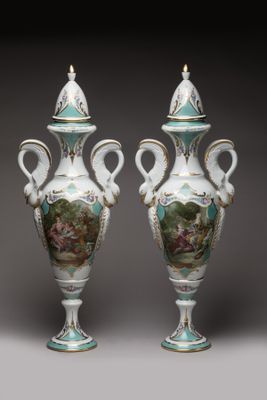 pair of vases with painted scenes on them on a gray background