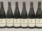 six bouteilles de vin sont alignées sur une table