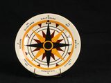 une assiette blanche ornée d'un motif représentant un compas jaune et noir