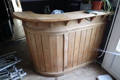 une photo d'un bar en bois au milieu d'une pièce
