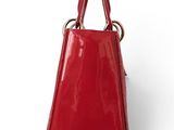 a red handbag on a white surface with a white background