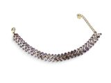 a close up of a purple and gold necklace on a white background