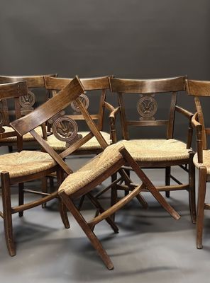 six wooden chairs are lined up in a circle on a gray floor