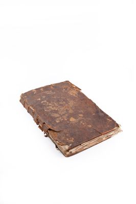 un vieux livre posé sur une surface blanche