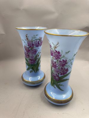 deux vases avec des fleurs peintes dessus, posés sur une table