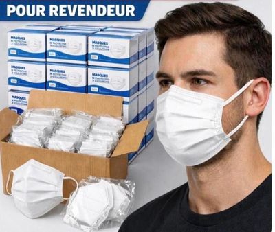 un homme portant un masque, à côté d'une boîte de masques jetables