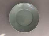 a green bowl sitting on a table with a white background