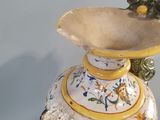 a vase that has a frog on top of it