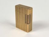 l'image d'un briquet doré posé sur une surface blanche