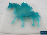 a blue plastic horse on a white plate on a table