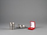a silver cup and a red cup next to each other