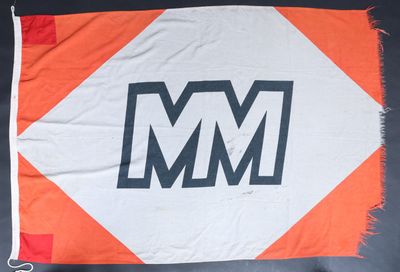 un drapeau orange et blanc sur lequel figure le logo « m m »