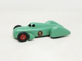 a green toy car that is sitting on a white surface