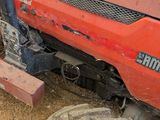 a red tractor that is parked in the dirt