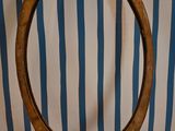 a wooden ring on a table with a striped wall behind it