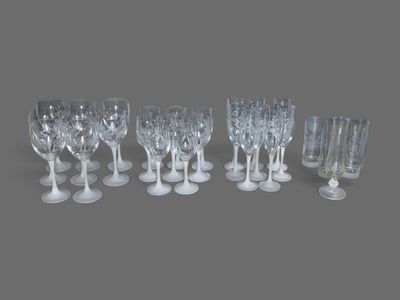 six verres à vin transparents et un verre à vin vide posés sur une surface grise
