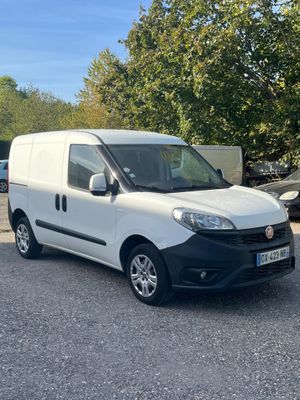 a white van parked in a parking lot next to a tree