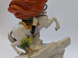 figurine of a man riding a horse with a red cape on his head
