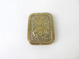 a small gold plate with a skull and crossbone on it