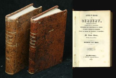 two old books sitting next to each other on a black surface