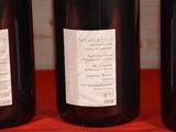 three bottles of wine sitting on a table with a red cloth