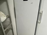 a white refrigerator next to a metal shelf in a kitchen
