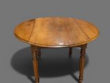une table à manger ovale en chêne, avec des pieds et un plateau tournés